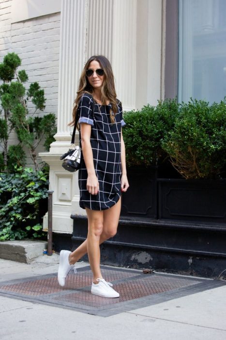 Chica usando un vestido de maternidad de color azul con líneas blancas 