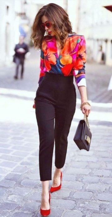 Chica usando una blusa de gasa con estampado floral y pantalones de color negro