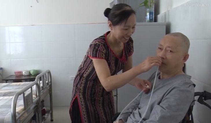La esposa de Li Zhihua le coloca la sonda para que respire bien por la nariz