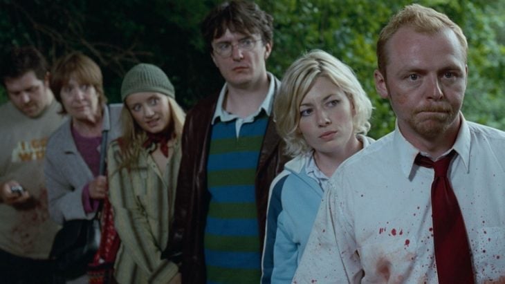 Escena de la película Zombies party , grupo de amigos escondidos tras unos arbustos 