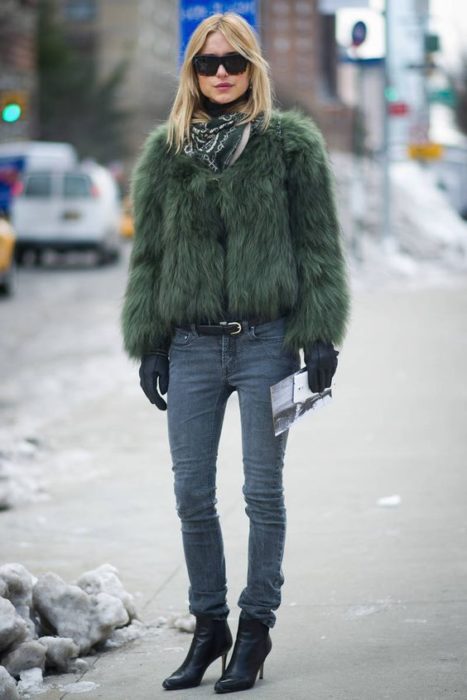 Chica usando un abrigo de color verde militar con jeans y botines 