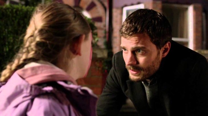 Jamie Dornan en su papel de the fall conversando con una niña 