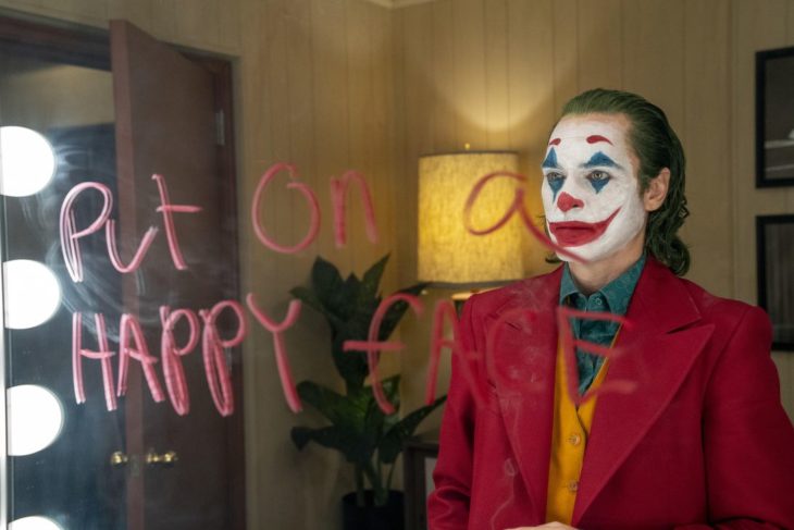 Actor Joaquin Phoenix en la película The Joker, mirándose frente a un espejo