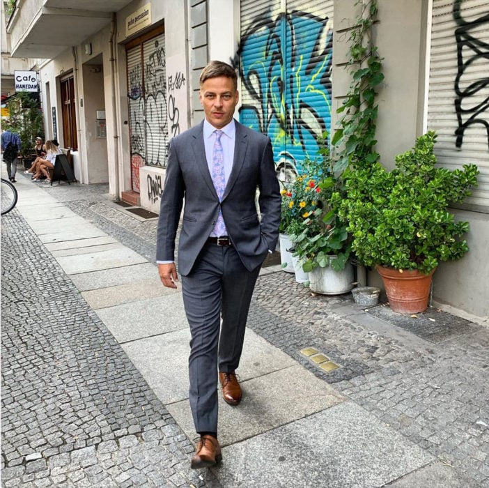 Actor Alemán usando un traje mientras camina por la calle 