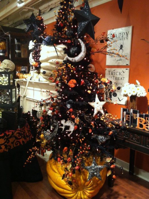 Pino navideño con ramas oscuras decorado con accesorios de Halloween