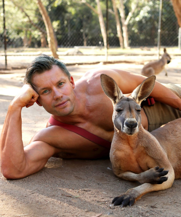 Calendario de bomberos australianos con animales; hombre musculoso con tatuajes y un canguro