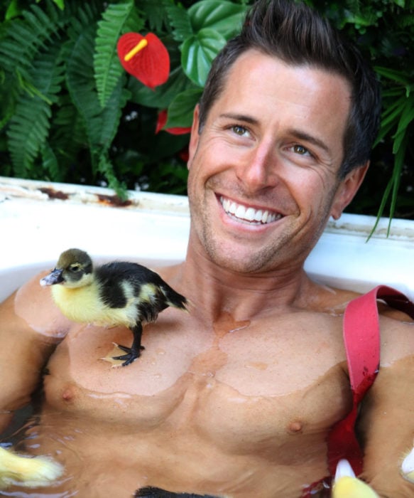 Calendario de bomberos australianos con animales; hombre sonriendo con un pato