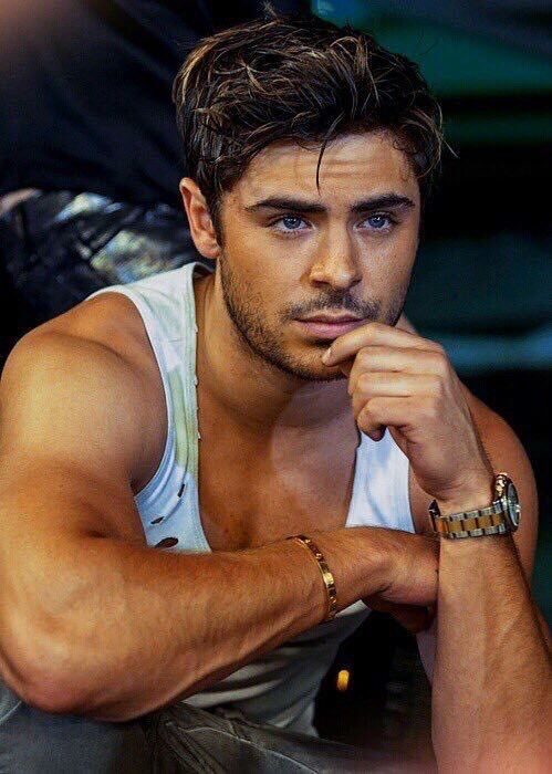 Zac Efron con camisa de tirantes pensativo 