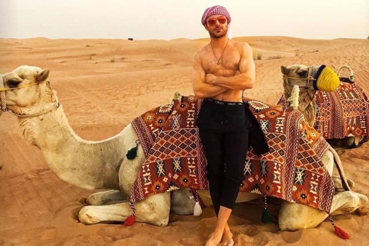 Zac Efron recargado en un camello en el desierto