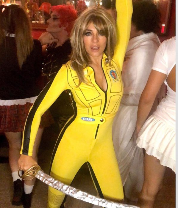 Elizabeth Hurley disfrazada como Beatrix Kiddo de Kill Bill con un traje de color morado y una espada 