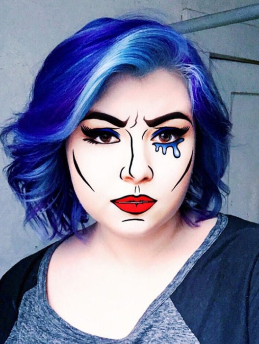 Disfraz de Halloween de comic pop art; chica de cabello azul con mechón blanco maqullada con estilo historieta 