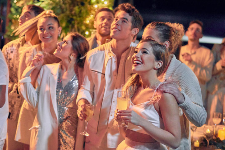 Escena de la película Go! la fiesta inolvidable. Chicos vestidos de blanco viendo hacia la nada 