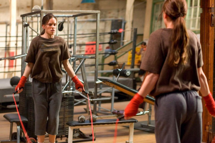 una mujer se ve en un espejo de un gimnasio saltando la cuerda