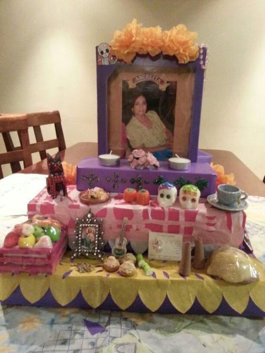 Altar de muertos decorados con papel picado, calaveritas de azúcar y catrinas de papel 