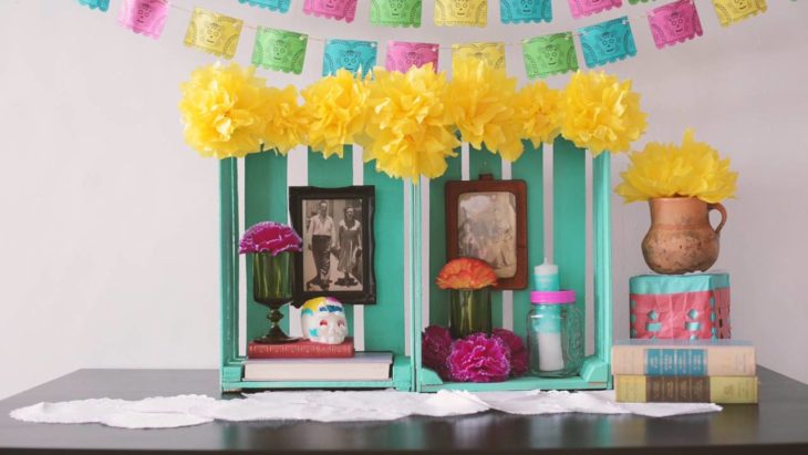 Altar de muertos decorados con papel picado, calaveritas de azúcar y catrinas de papel 