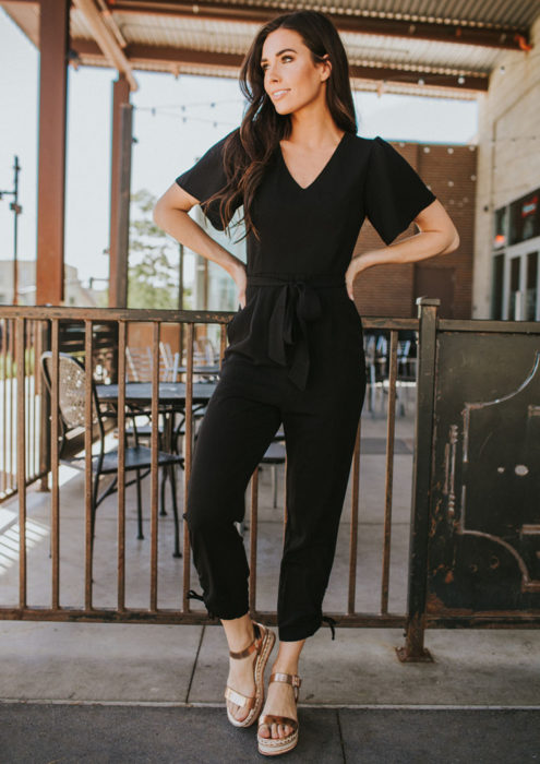 Looks con jumpsuit; chica de cabello castaño y largo, con un enterizo color negro de mangas cortas y sandalias abiertas