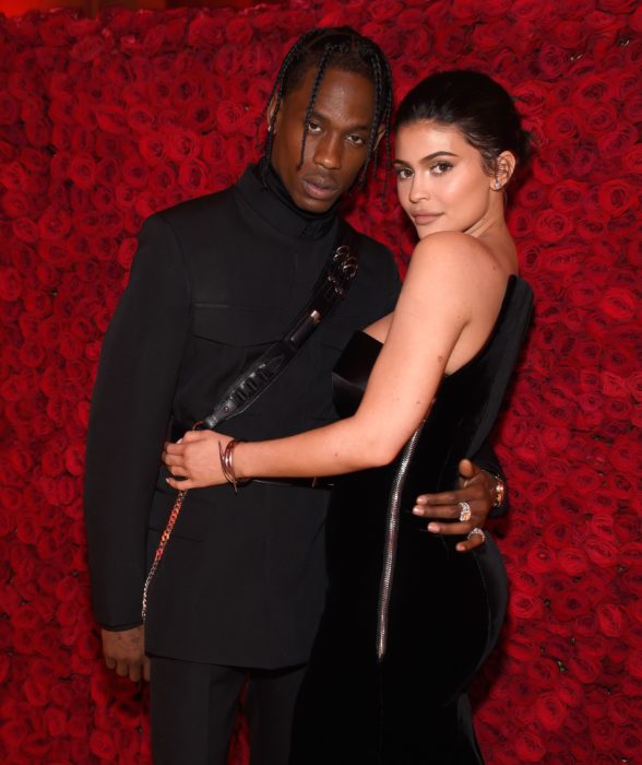 Kylie Jenner y Travis Scott se separan; pareja frente a una pared de rosas rojas