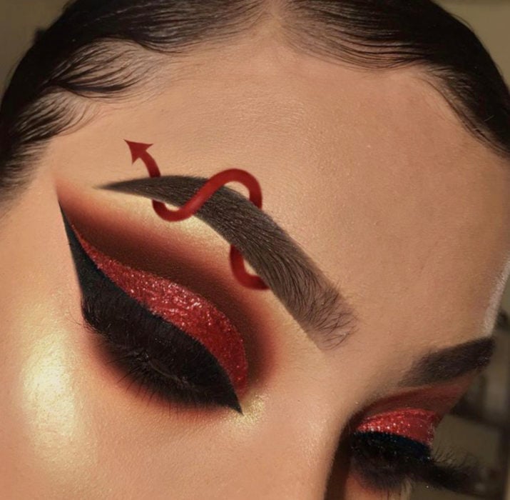 Maquillaje de ojos de Halloween; sombra roja con cola de diablo en la ceja