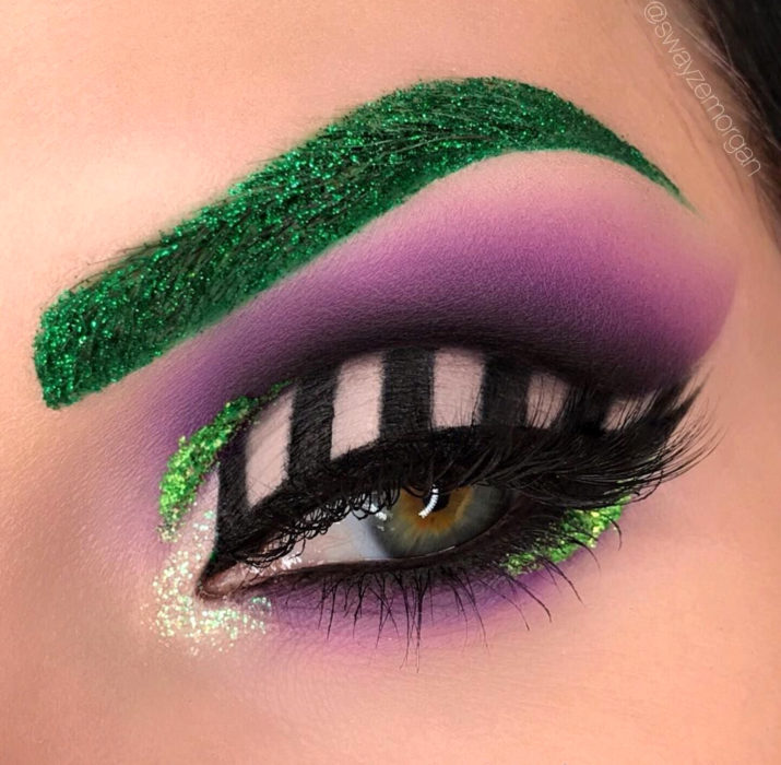 Maquillaje de ojos de Halloween; sombra morada, blanca con rayas negras y ceja verde de Beetlejuice