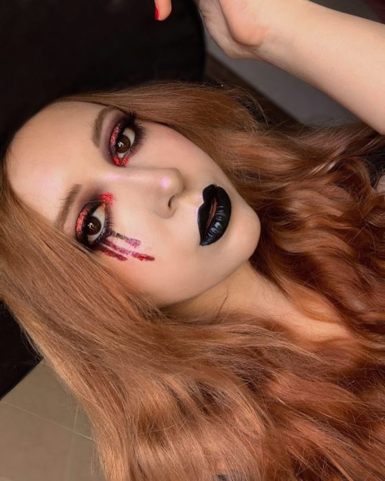 Chica con maquillaje en forma de lagrimas en tono rojo 