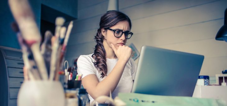 Mujer con lentes frente a una computadora en el escritorio