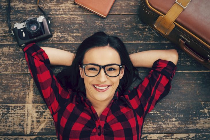 Mujer con camisa de cuadros rojo y negro, con lentes