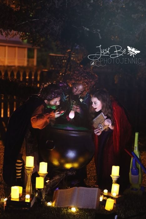Niñas disfrazadas de la película de brujas Hocus Pocus para Halloween; Winifred, Sarah y Mary Sanderson; caldero
