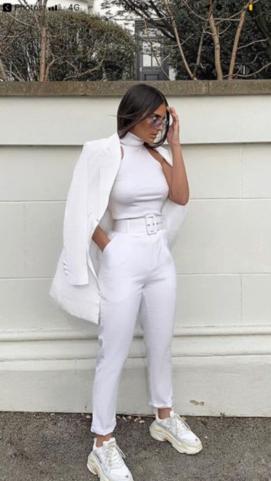 Chica con un outfit totalmente blanco con unos tenis fila de color blanco 