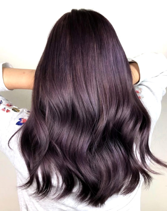 Tinte color chocolate lila; chica con cabello castaño morado, largo y lacio, ondulado de las puntas