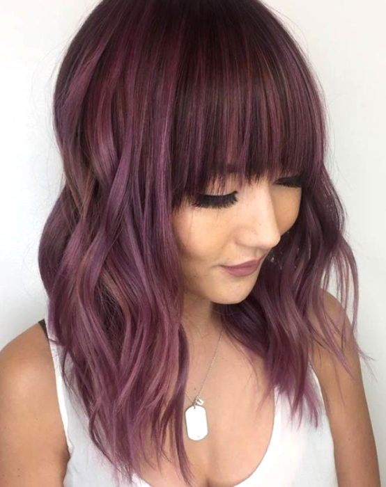 Tinte color chocolate lila; chica con cabello castaño morado, abajo de los hombros, con fleco