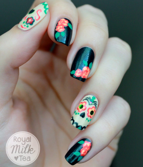 Manicura de Día de Muertos; uñas largas y cuadradas, pintadas con esmalte negro con calaveras y flores