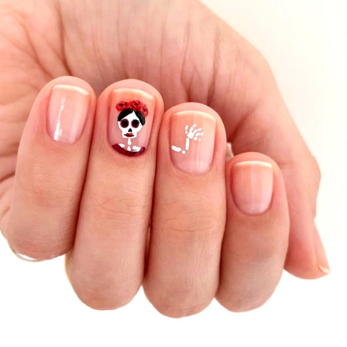 Manicura de Día de Muertos; uñas cortas con esmalte transparente con diseño de catrina