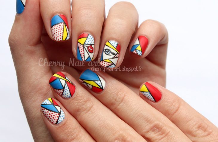 Manos de una chica con diseño de uñas pop art en color blanco con viñetas 