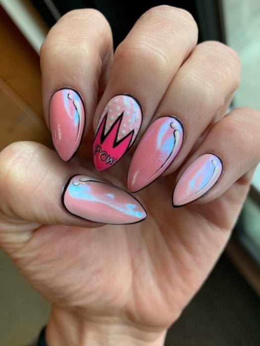 Manos de una chica con diseño de uñas pop art en color rosa 