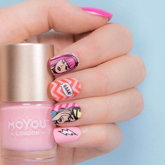 Manos de una chica con diseño de uñas pop art en color rosa con etiquetas 