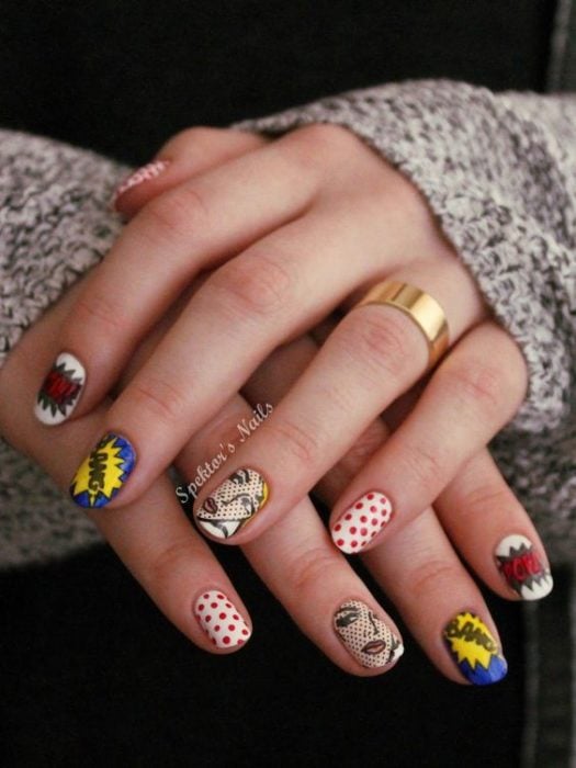 Manos de una chica con diseño de uñas pop art en color blanco con viñetas de cómics 
