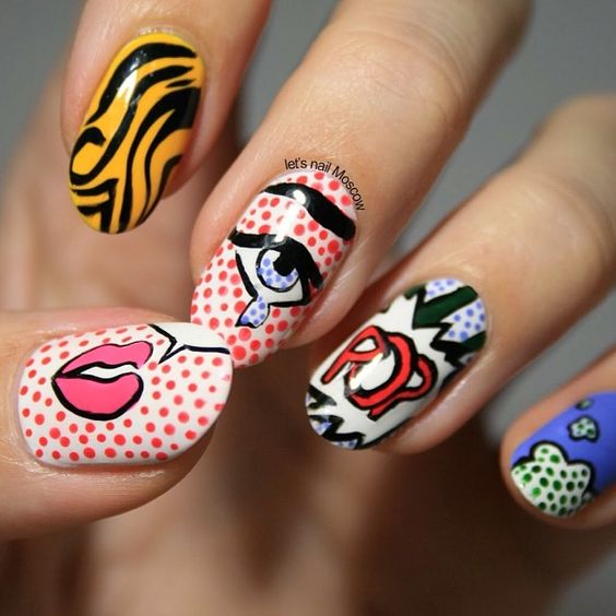 Manos de una chica con diseño de uñas pop art en colores con diferentes colores