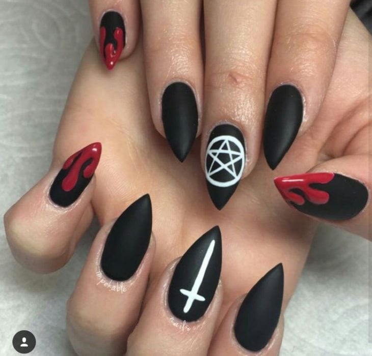 Chica con unas uñas de color negro con diseños de color rojo y blanco 
