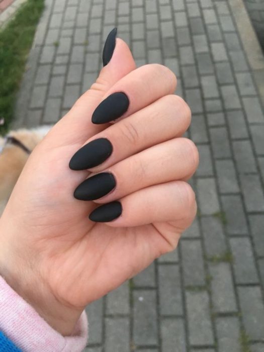 Chica mostrando sus uñas de color totalmente negro 