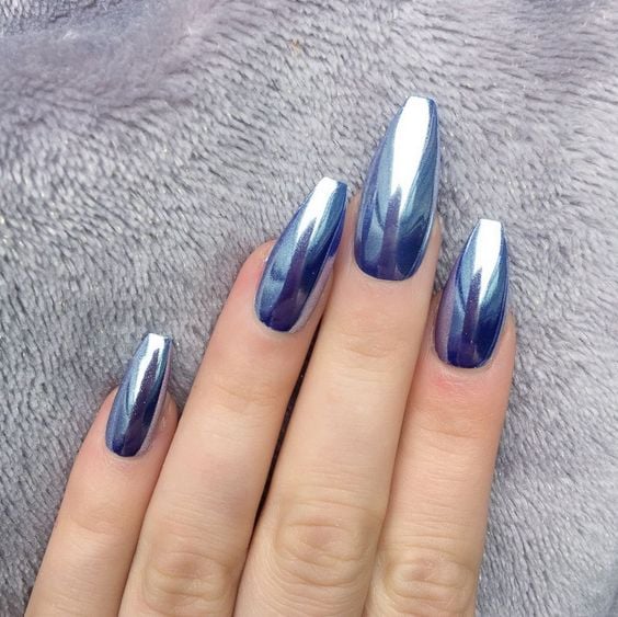 Chica mostrando sus uñas de color azul cromado 