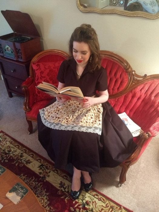 Katrina Holte vestida al estilo de los años 50 en un sillón de su sala vintage