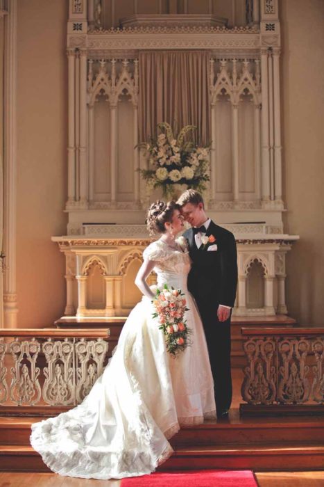 Katrina y Lars Holte el día de su boda frente al altar de la iglesia