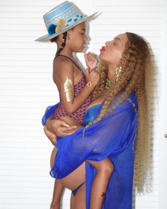 Beyonce embarazada cargando a su hija blue Ivy mientras posan para una sesión de fotos