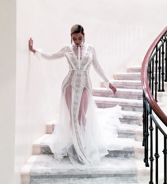 Beyonce bajando las escaleras mientras usa un vestido blanco para ir a un evento