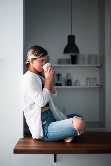 Mujer disfrutando su soledad tomando una taza de café