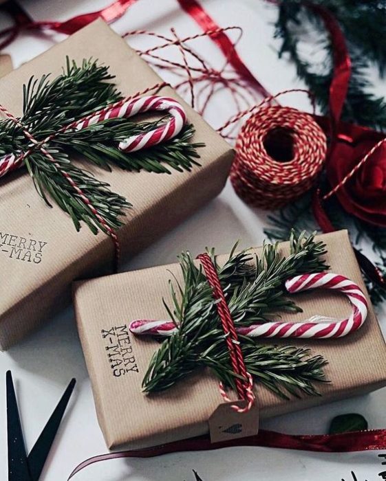 Caja de cartón decorada con hierbas navideñas y caramelos de bastón 