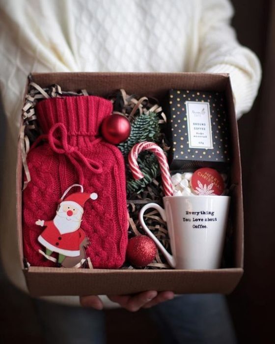 Caja de regalo rellena con guantes de estambre, una taza y caramelos