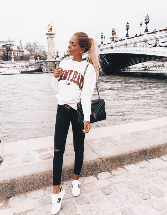 Chica usando una sudadera de color blanco con jeans y tenis del mismo color 