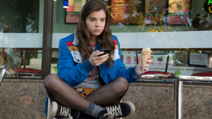 Escena de la película Mi vida a los 17. Chica sentada frente a una heladería comiendo un cono 
