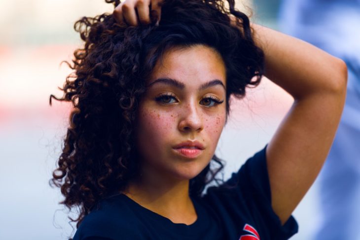 Chica con cabello rizando, posando para una fotografía 